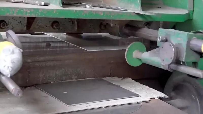 Una gran chapa de acero está siendo cortada en piezas pequeñas por la máquina