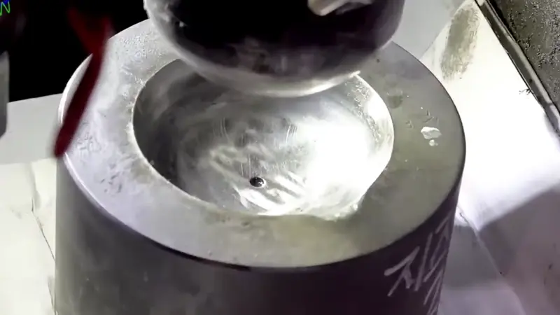 Un trabajador está moldeando los cucharones de acero inoxidable