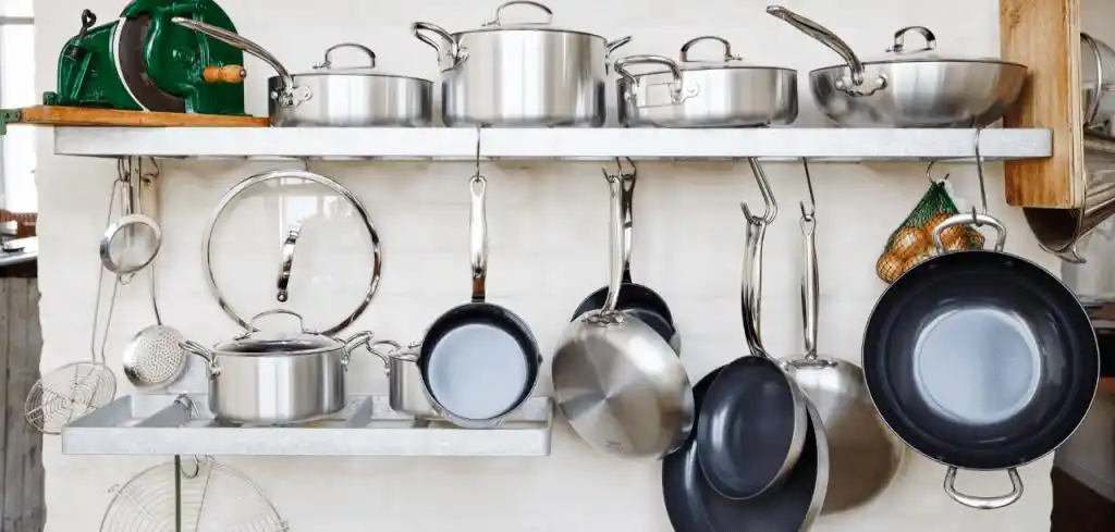 The kitchen wall shelves are filled with stainless steel kitchenware.