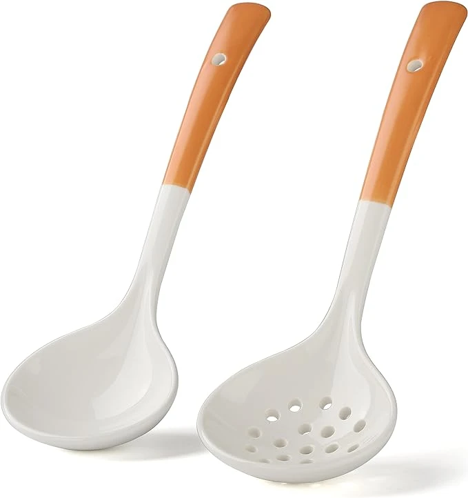 Ceramic cooking utensils with orange handle against white background