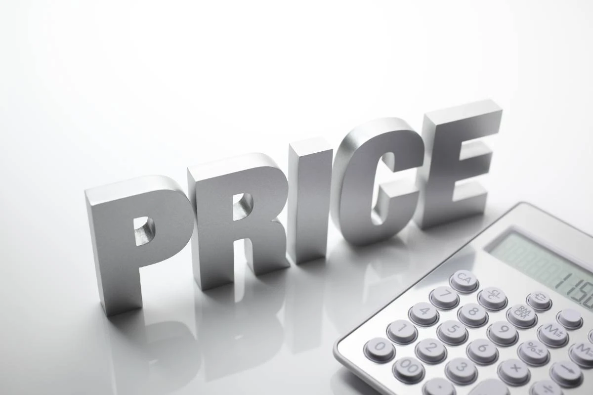 a silver "PRICE" sign beside a calculator