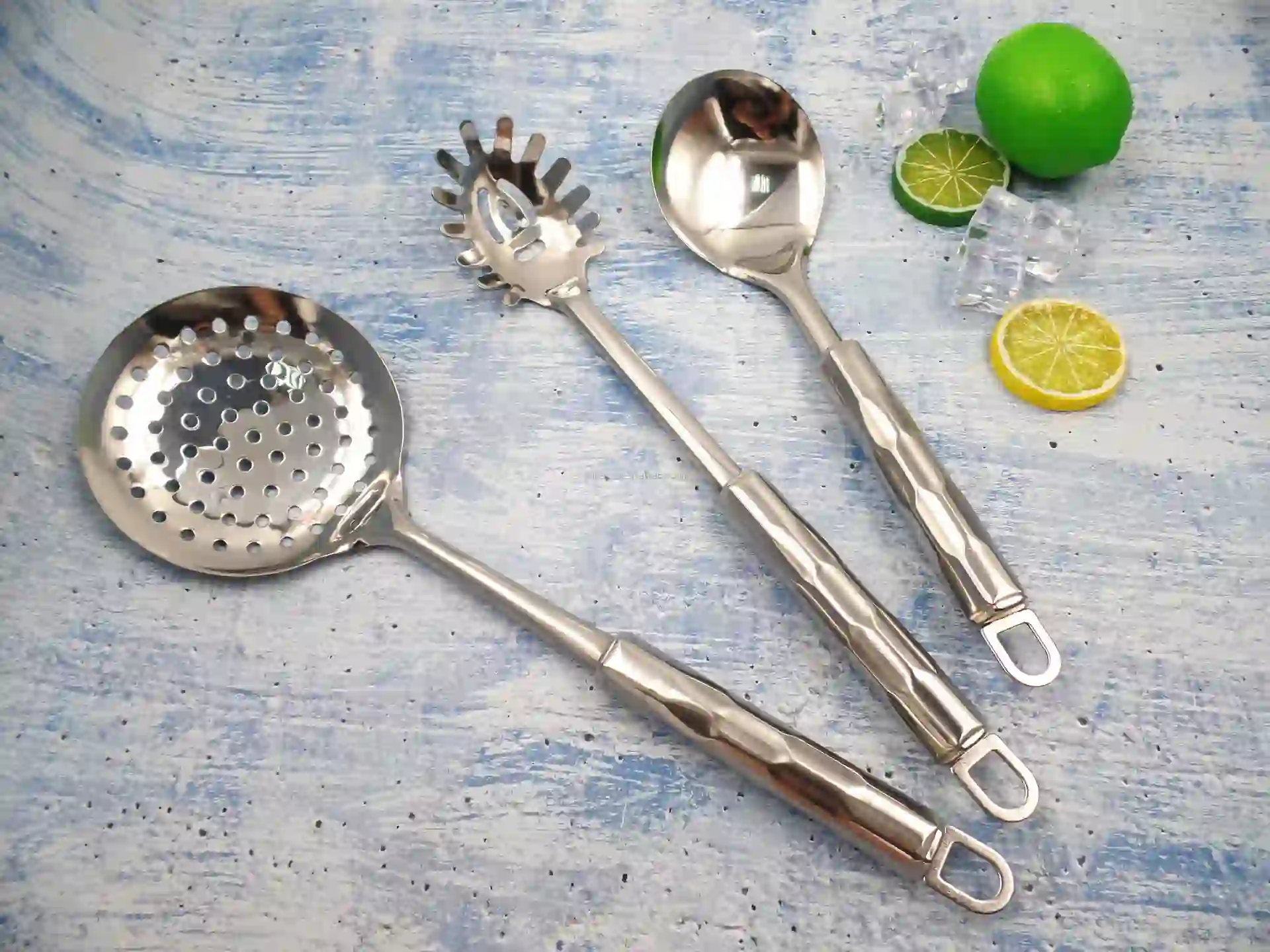 Stainless steel kitchen utensils and lemons on the blue and white cloth