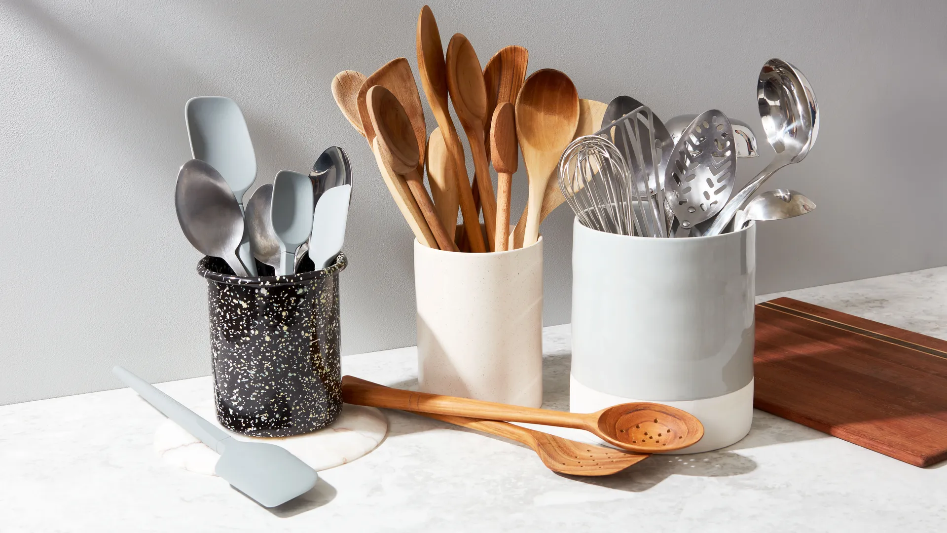 Three utensil crocks filled with kitchen utensils