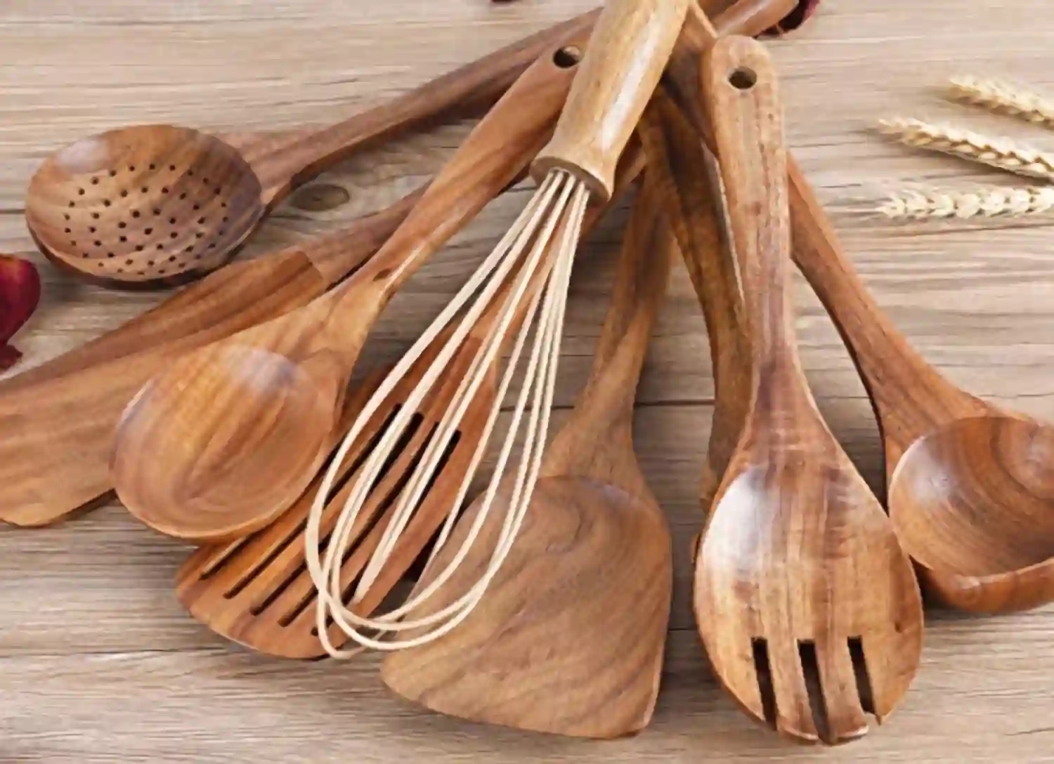 Set of wood cooking utensils displayed on a rustic wooden table