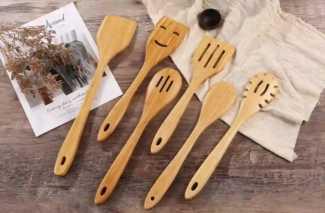 Set of bamboo cooking utensils sit on a wooden tabletop