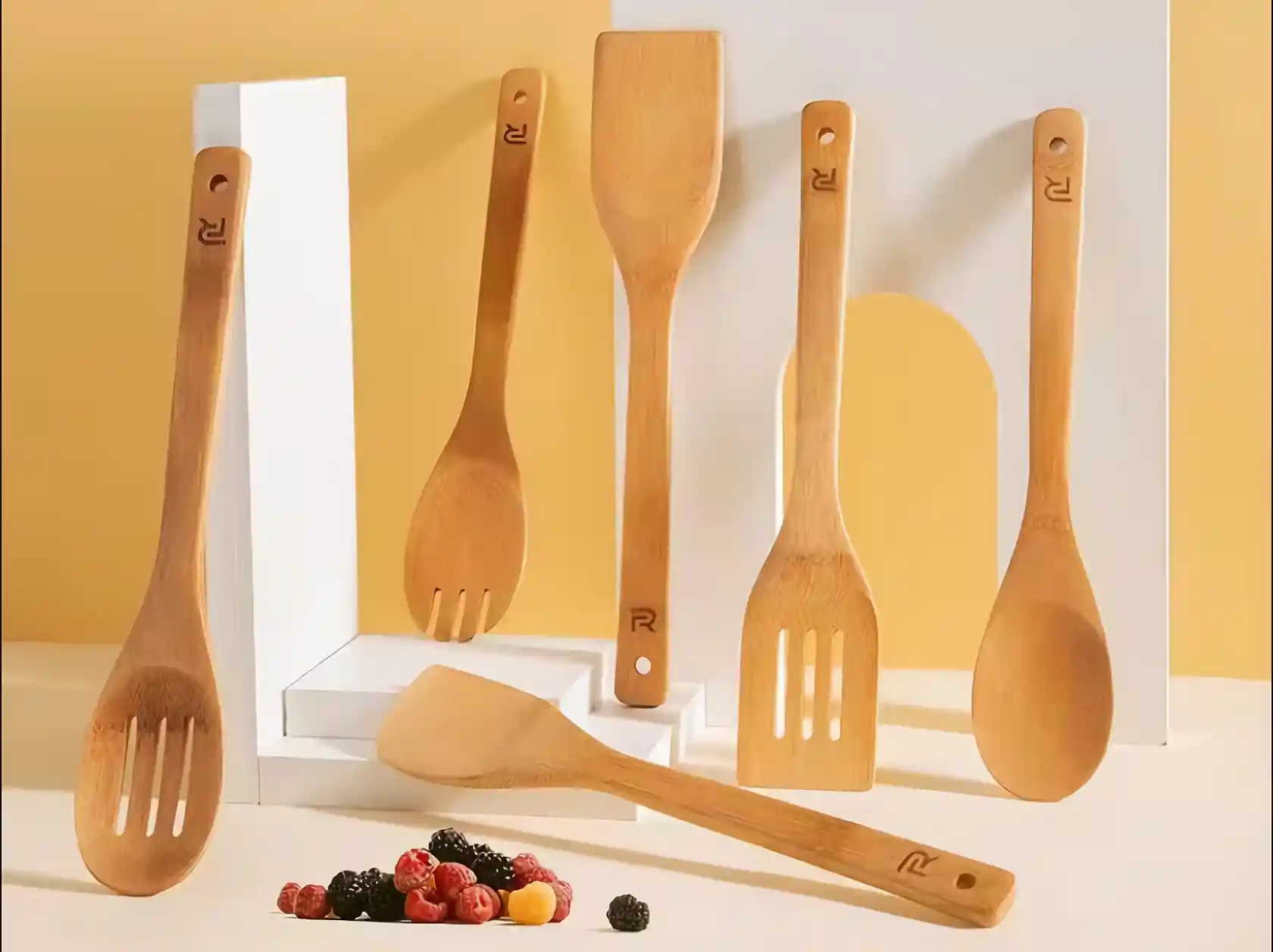 Bamboo kitchen cooking utensils sit on the white countertop