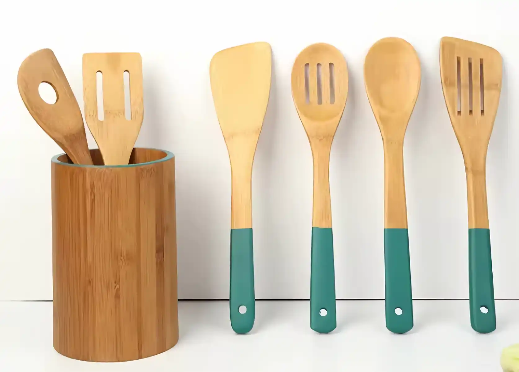 Bamboo cooking utensils sit on the white countertop