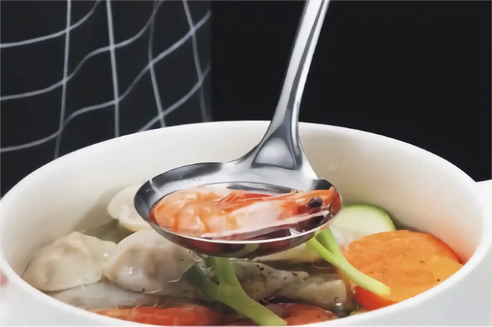 A stainless steel soup ladle scooped up the delicious shrimp soup